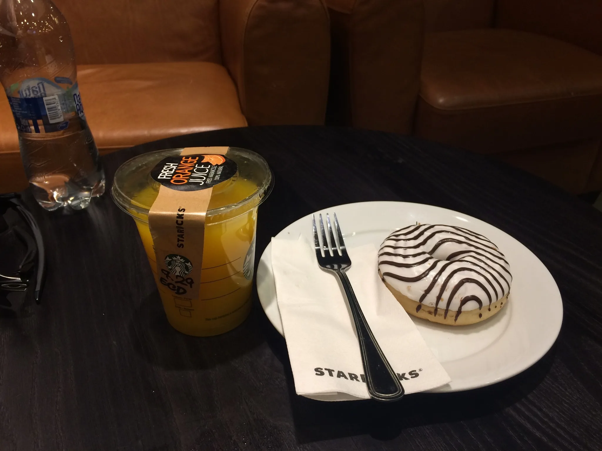 Starbucks narancsital és fánk márkázott szalvétával egy asztalon