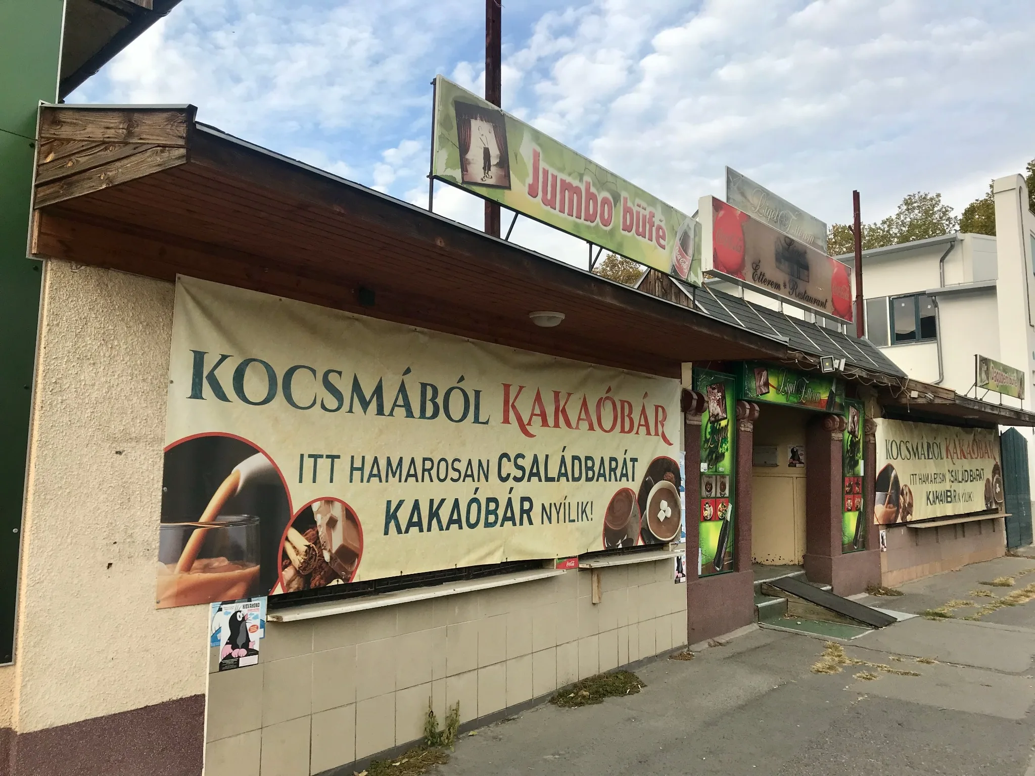 Étterem homlokzata Kocsmából kakaóbár és családbarát kakaóbár nyílik feliratú molinóval