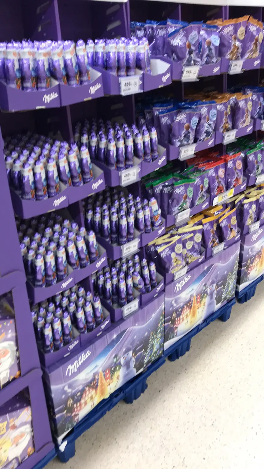 Milka-termékekből és lila displayekből kialakított, összefüggő márkablokk egy üzlet polcán