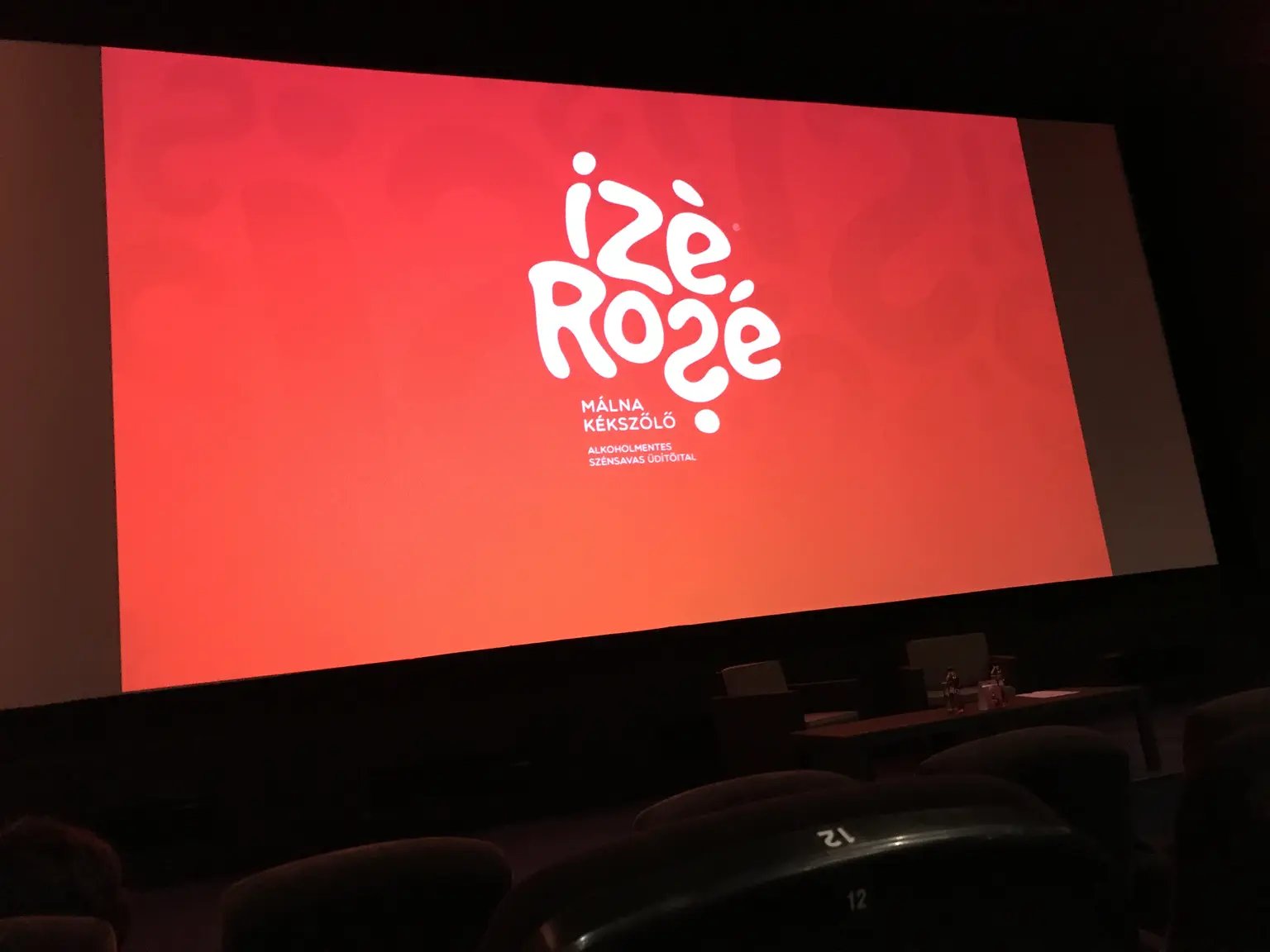 Ízé Rozé logó nagyméretű vetítővásznon egy rendezvénytérben