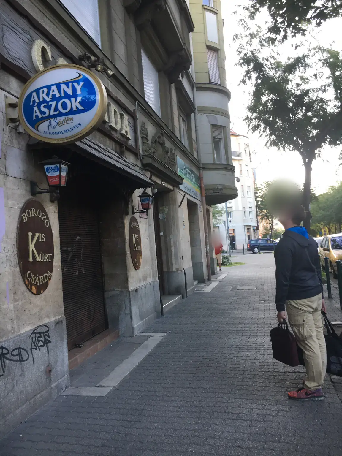 Utcai nézet az Arany Ászok cégérrel, Borozó és Kis Kürt Csárda felirattal jelölt homlokzatról