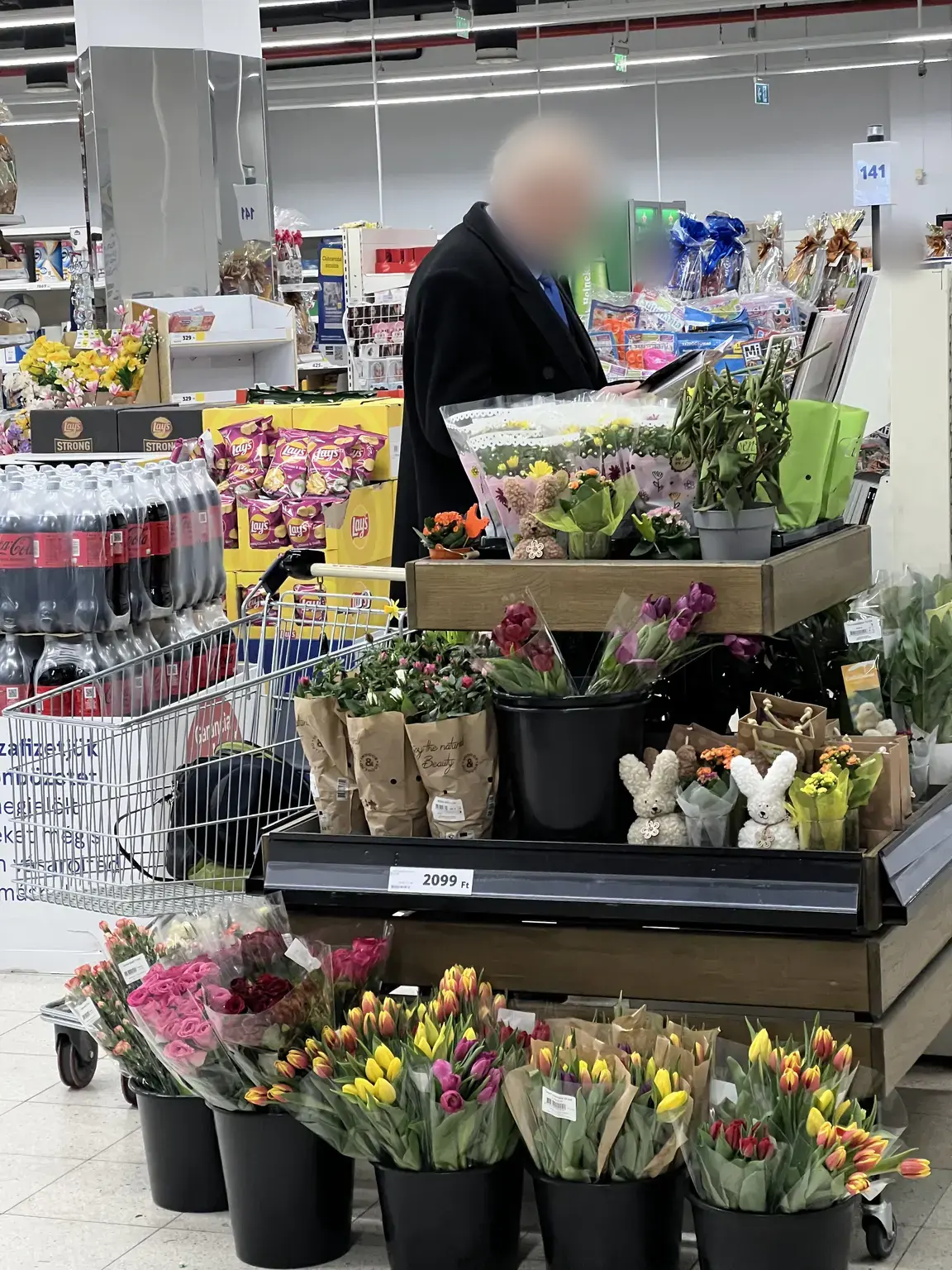 Színes virágokból és szezonális nyúlfigurákból kialakított bolti terméksziget 2099 forintos árjelzéssel Egerben