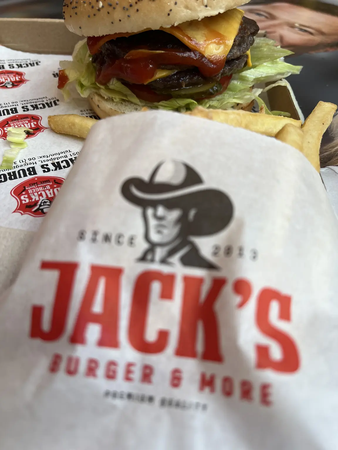 Hamburger és sült krumpli Jack’s Burger & More logóval ismételten nyomtatott csomagolásban Dunakeszin
