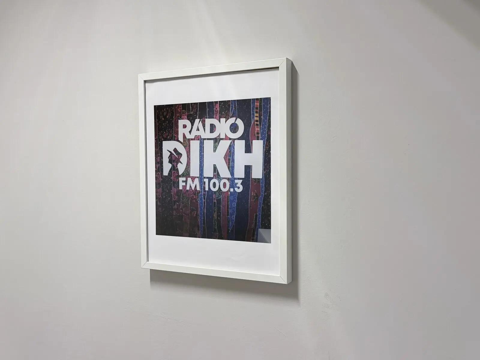 Keretezett Rádió 1 Eger FM 100.3 márkajel egy világos falon