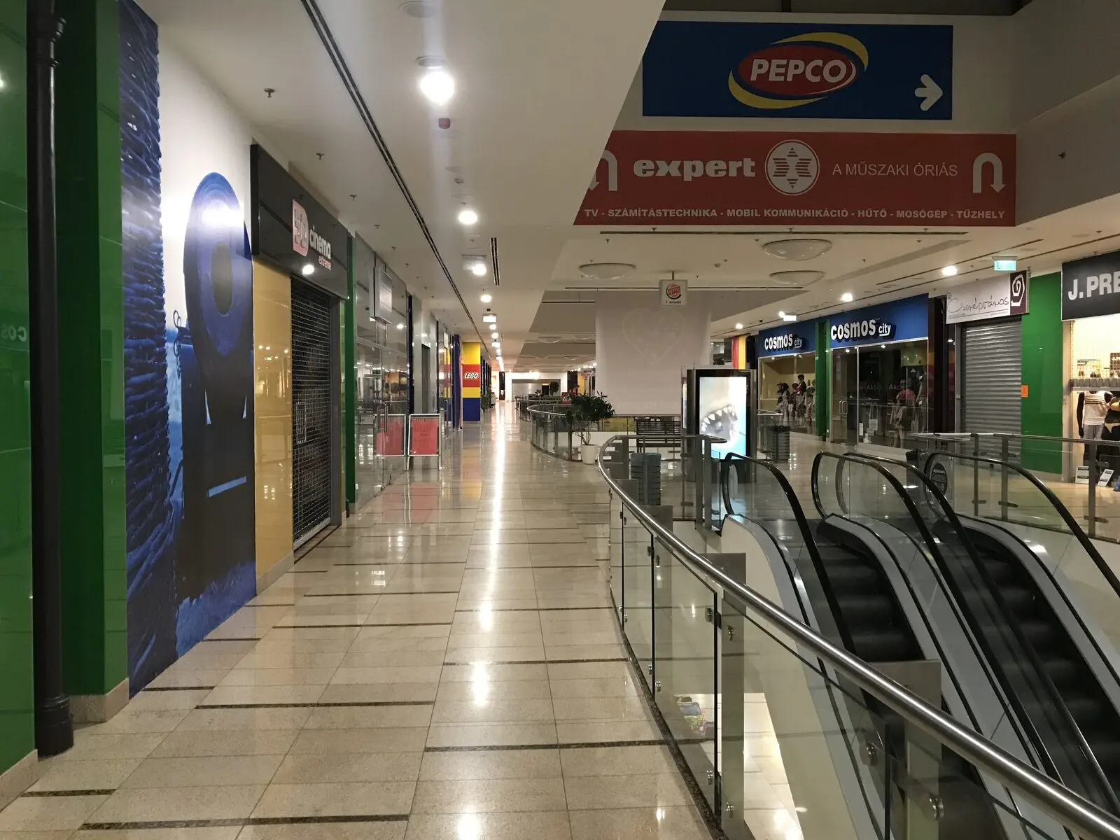 Bevásárlóközpont folyosója mennyezet alatti Pepco és Expert márkatáblákkal