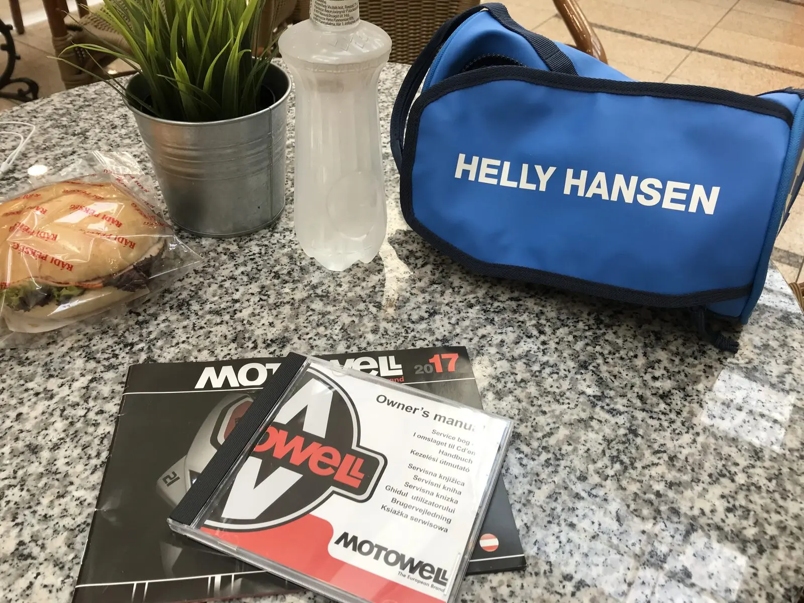 Motowell kézikönyv és lemez egy Helly Hansen márkázott táska mellett