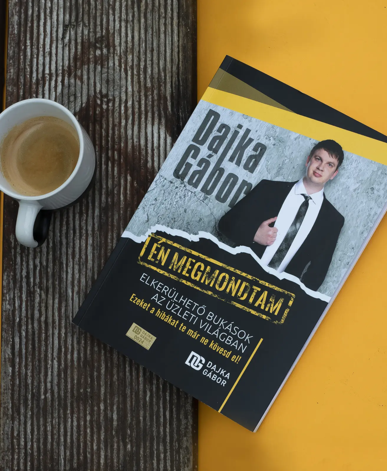 Dajka Gábor könyve kávéval és sárga háttérfelülettel