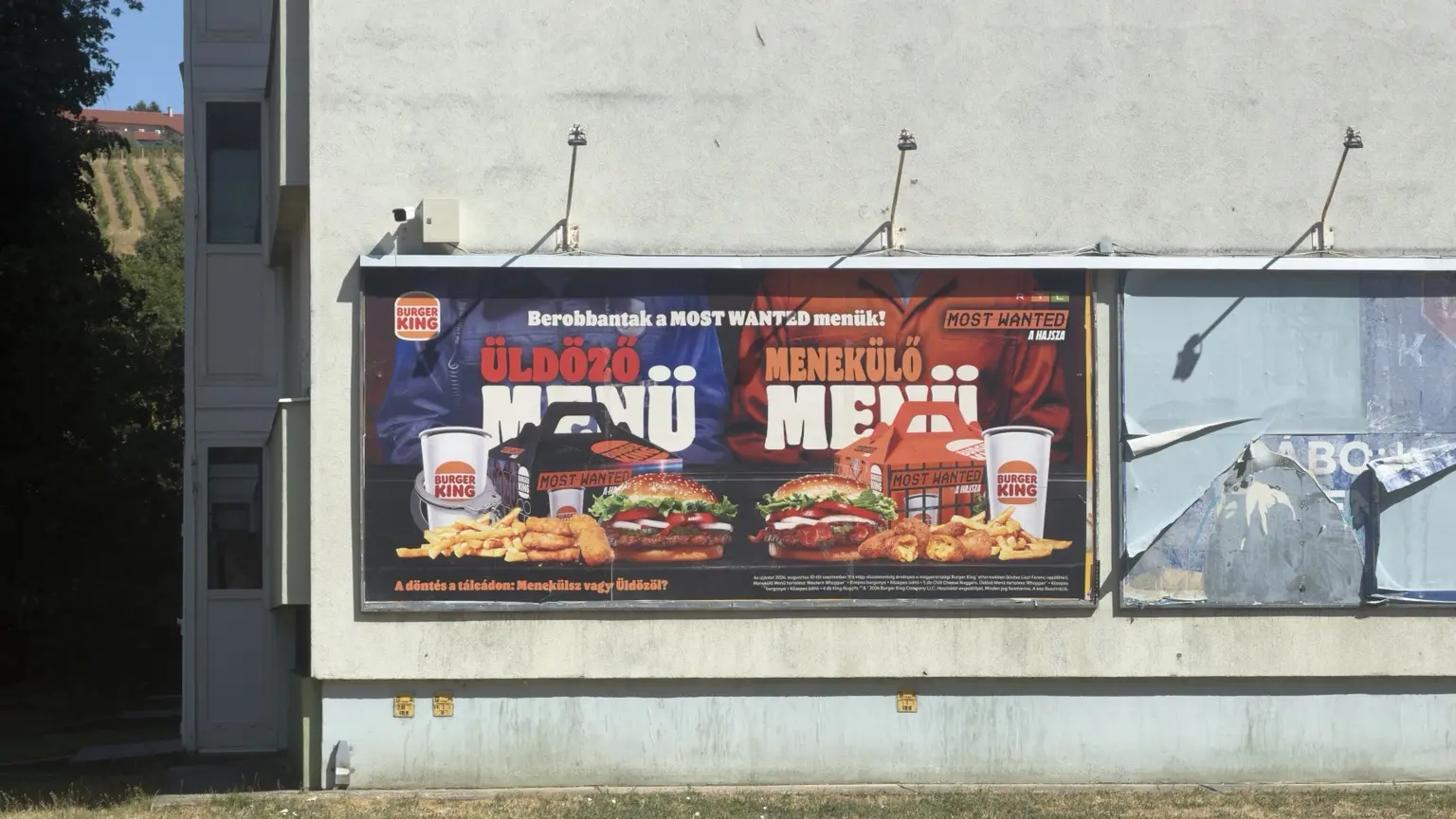 Burger King Most Wanted óriásplakát Üldöző és Menekülő menüvel, kék és narancssárga oldalakra bontva