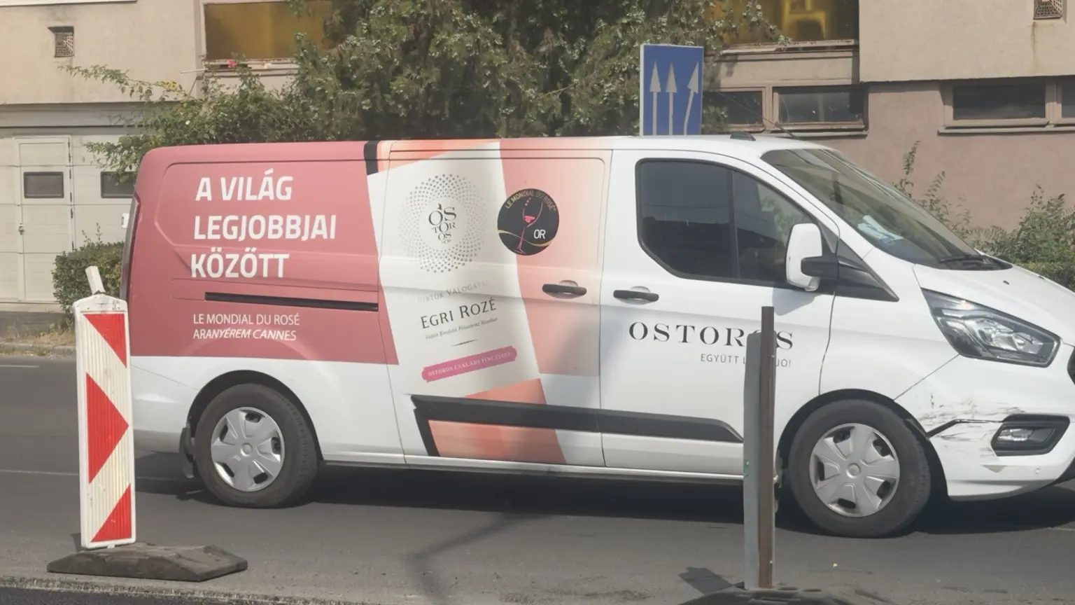 Ostoros márkajelzésű kisteherautó A világ legjobbjai között felirattal, Egri Rozé palackkal és Le Mondial du Rosé aranyérem jelzéssel