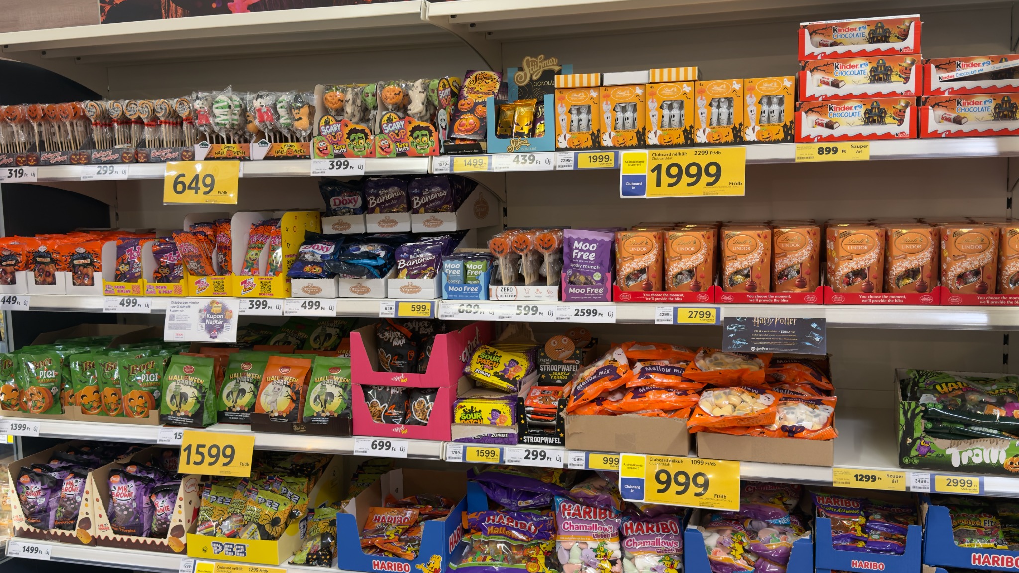 A Tesco Halloween-polc részlete nyalókákkal, csokoládékkal, gumicukrokkal, pillecukrokkal és Clubcard-árjelzésekkel
